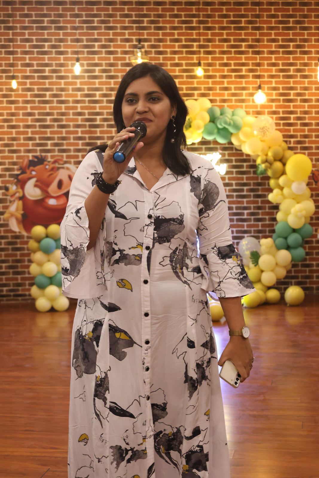Anchor Ananya Kundu with microphone at an evening event