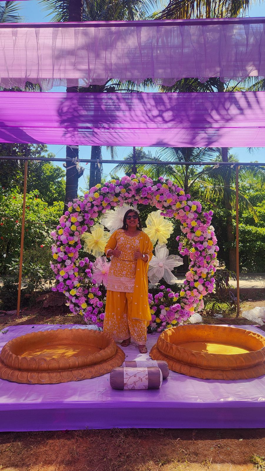 Anchor Ananya Kundu beside a marigold arch at a haldi